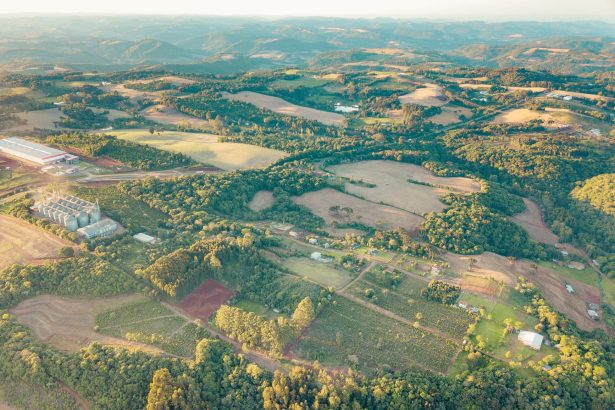 Vista aérea de áreas agrícolas e do campo no Centro do Rio Grande do Sul, durante o dia.